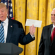 President Trump holding the letter from Barack Obama. Image via the AP.